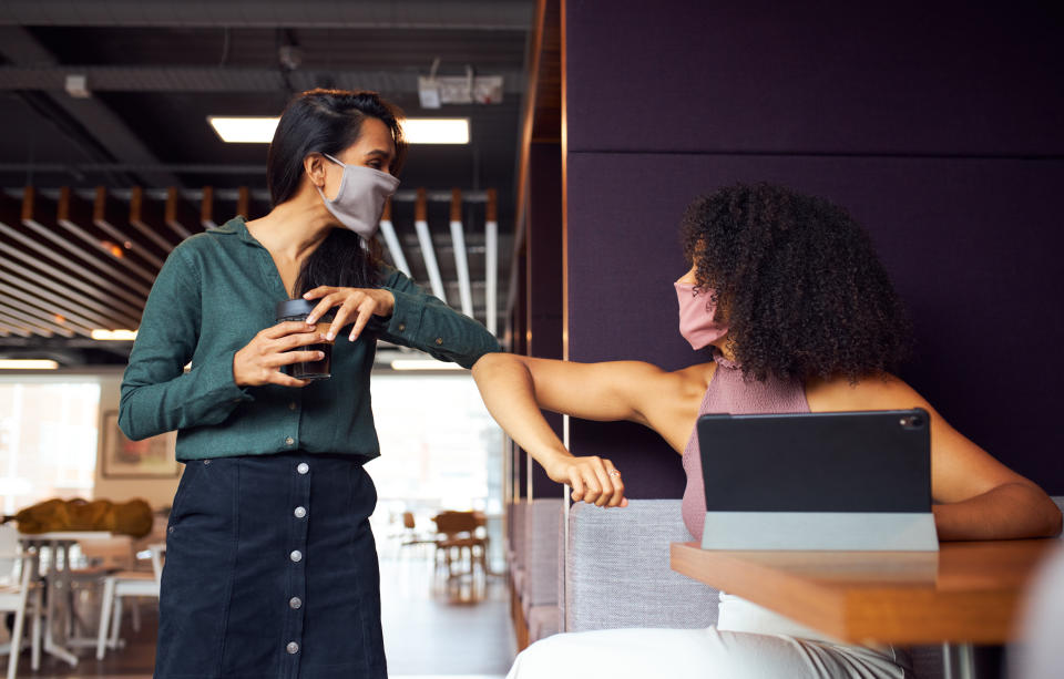 Businesswomen Wearing Masks Have Socially Distanced Meeting In Office Cubicle During Health Pandemic