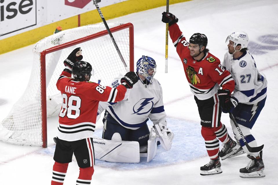 Chicago Blackhawks left wing Alex DeBrincat (12) and right wing Patrick Kane (88) celebrate after DeBrincat scored a goal past Tampa Bay Lightning goaltender Andrei Vasilevskiy (88) as Lightning defenseman Ryan McDonagh (27) looks on during the third period of an NHL hockey game, Sunday, March 6, 2022, in Chicago. (AP Photo/Matt Marton)