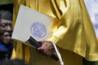 A Jackson State member of the Class of 1970 carries her diploma, as one of 74 graduates honored by the historically Black university with an official graduation ceremony, Saturday, May 15, 2021, in Jackson, Miss. The ceremony was held 51 years after the school canceled its 1970 graduation ceremony after white law enforcement officers marched onto campus near the end of the spring semester and violently suppressed protests against racism with gunfire, killing two and wounding 12. (AP Photo/Rogelio V. Solis)