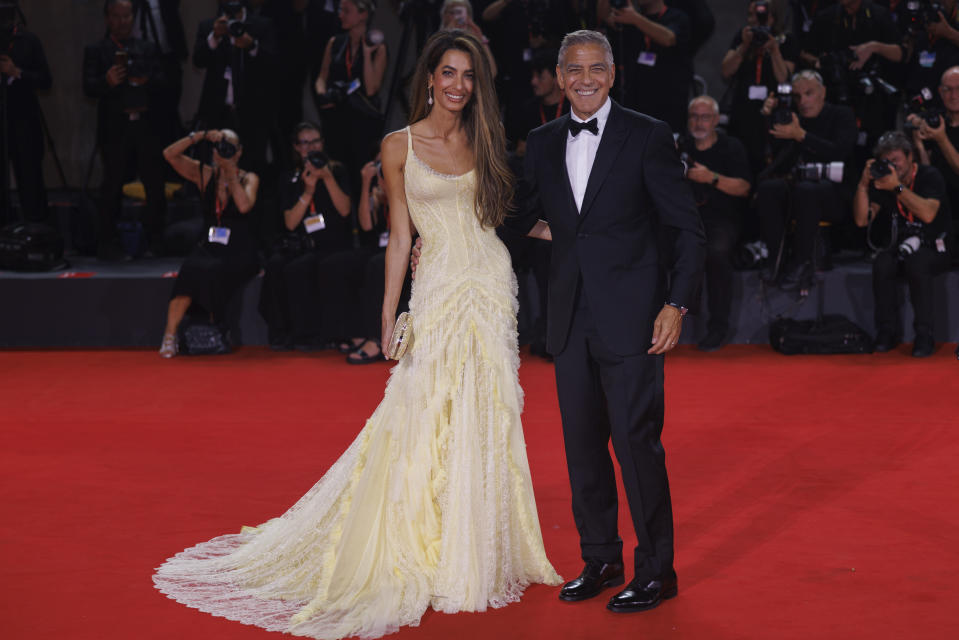 Amal Clooney and George Clooney pose for photographers on the red carpet.