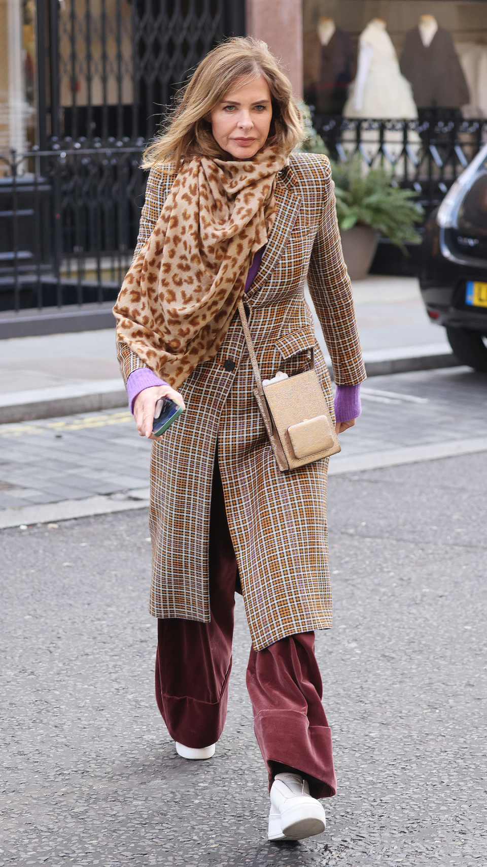 <p> There's nothing like a classic winter coat to smarten up your look. Woodall opted for a sharp tweed option to dine at Scott's Mayfair restaurant in London in 2022. She paired it with burgundy red trousers, as well as a beige cross-body bag and an animal print scarf wound around her neck. </p>