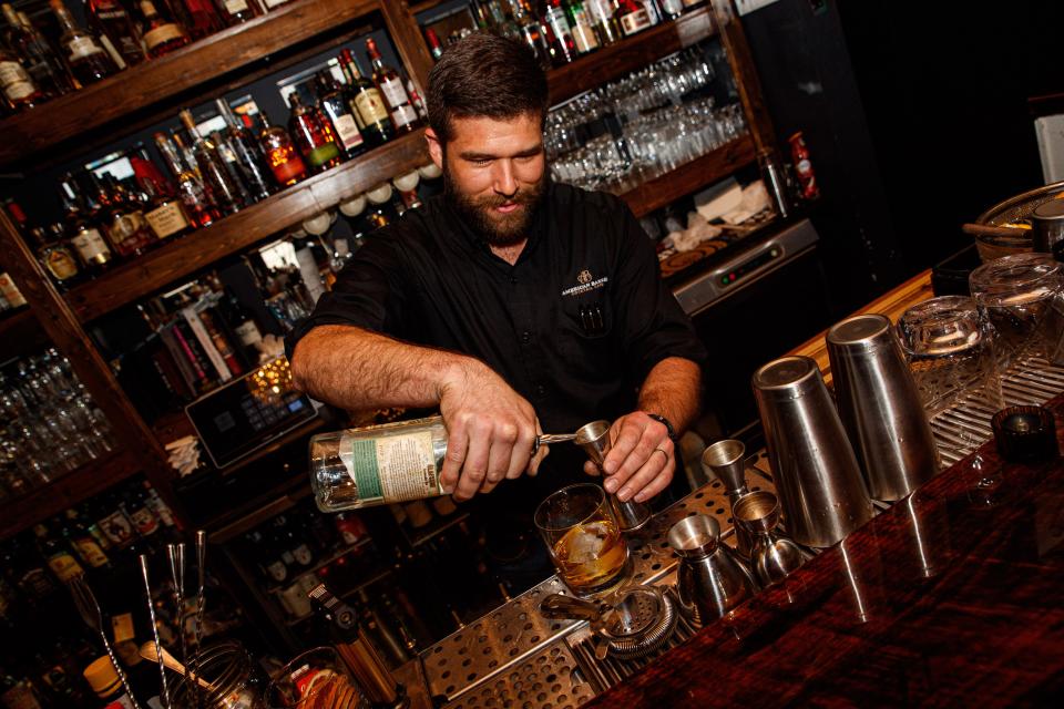 Nathan Close, a co-owner with his wife America, makes an old fashioned at American Barrel in Columbia, Tenn. on Apr. 20, 2023. 