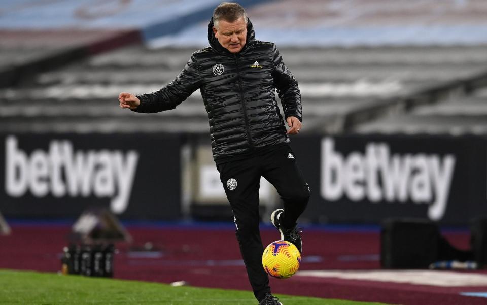 Chris Wilder controls ball in tracksuit trousers and gillet - AFP