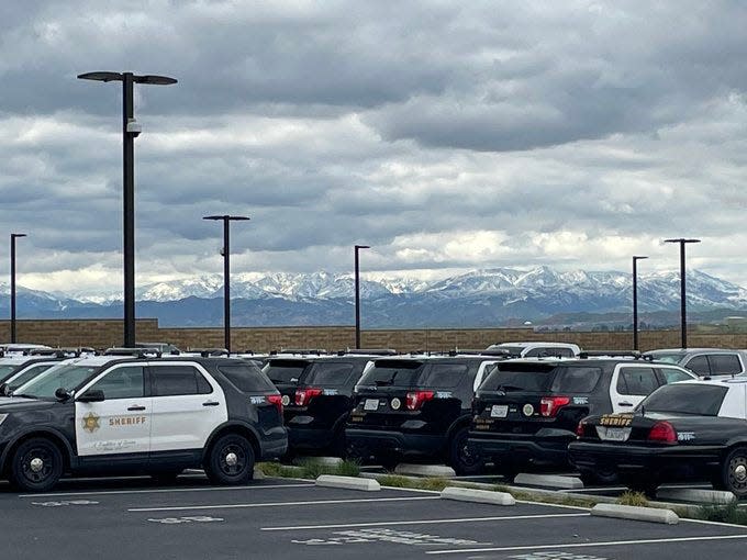 Mountain snow, seen behind patrol vehicles at the Los Angeles County Sheriff's station in the Santa Clarita Valley, closed the Grapevine on Wednesday, March 1, 2023.