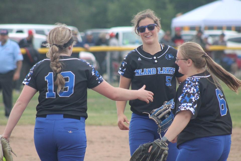 Inland Lakes' Maggie Grant (19), Natalie Wandrie (middle) and Caleigh Jones (6) celebrate an out during a recent Division 4 regional softball semifinal against Johannesburg-Lewiston in Rudyard.