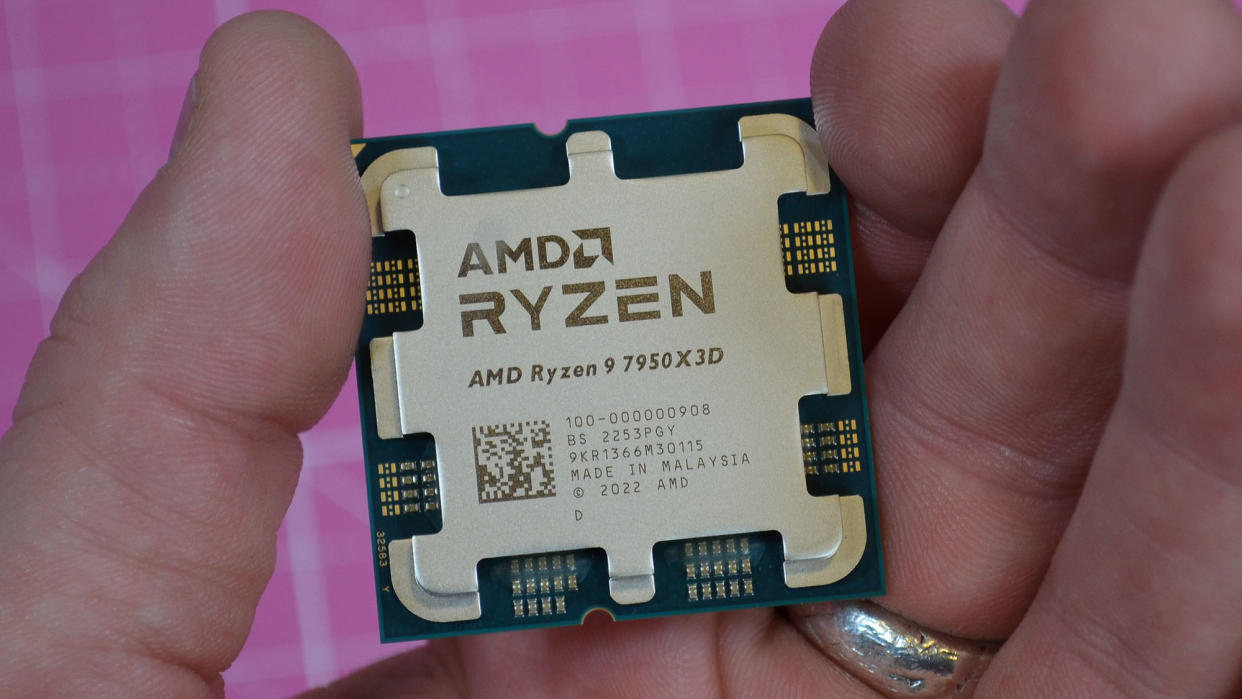  An AMD Ryzen 9 7950X3D held between a man's fingers. 