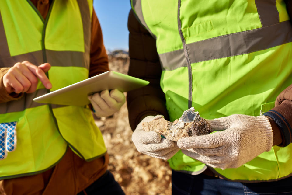 Miners inspect a piece of mineral.