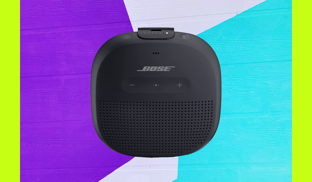 Black Bose wireless speaker shown on a purple and blue background. 