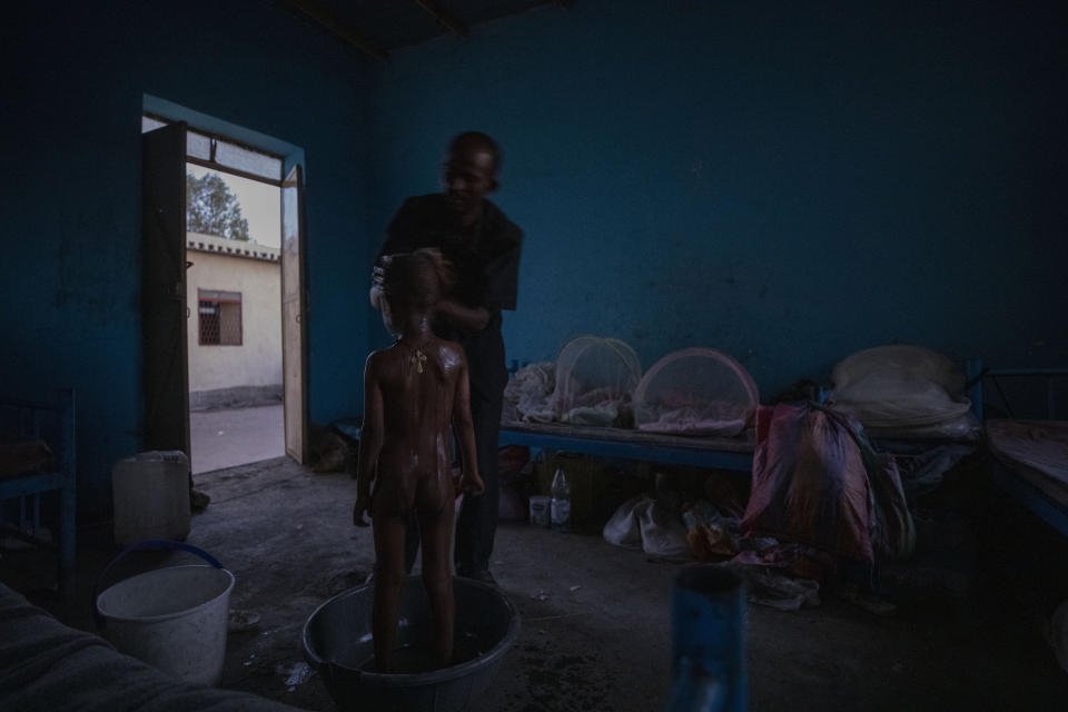 Tigrayan refugee Abraha Kinfe Gebremariam, 40, bathes his 5-year-old son, Micheale, after waking up early in the morning in their shelter in Hamdayet, eastern Sudan, near the border with Ethiopia, on March 21, 2021. (AP Photo/Nariman El-Mofty)