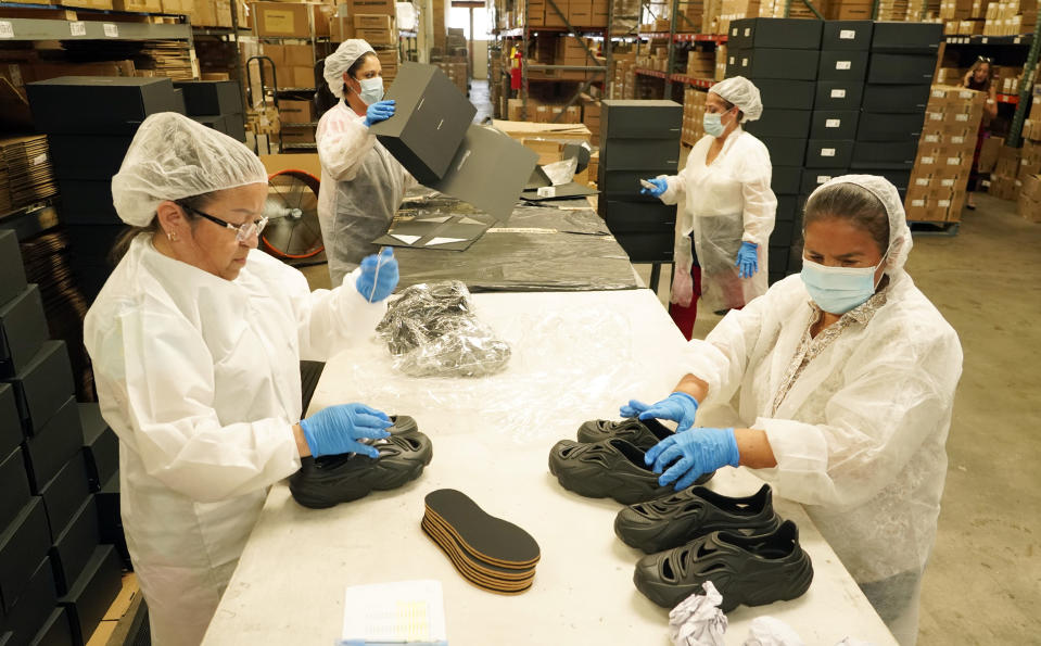 Gabriella Villanueva, clockwise from left, Marina Medina, Gladys Sibrian and Margarita Enriquez assemble Plastic Soul shoe packages at the Doc Johnson factory and corporate offices, Thursday, Aug. 18, 2022, in Los Angeles. Streetwear label Rose in Good Faith and sex toy company Doc Johnson have partnered to create a shoe derived in part from unused or defective sex toys. (AP Photo/Chris Pizzello)