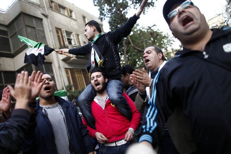 Protesters wave the pre-Baath Syrian flag, now used by the Free Syrian Army, as they shout slogans against the Syrian and Iranian regimes during a demonstration outside the Iranian embassy in the Egyptian capital Cairo on February 6, 2013