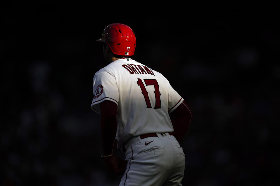 A shaft of light falls on Los Angeles Angels' Shohei Ohtani, of Japan, as he stands near third base during the first inning of a baseball game against the Houston Astros Tuesday, July 12, 2022, in Anaheim, Calif. (AP Photo/Jae C. Hong)