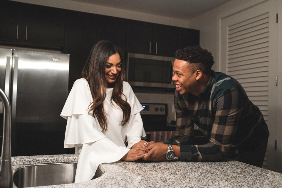 a newly wed couple laughing in the kitchen