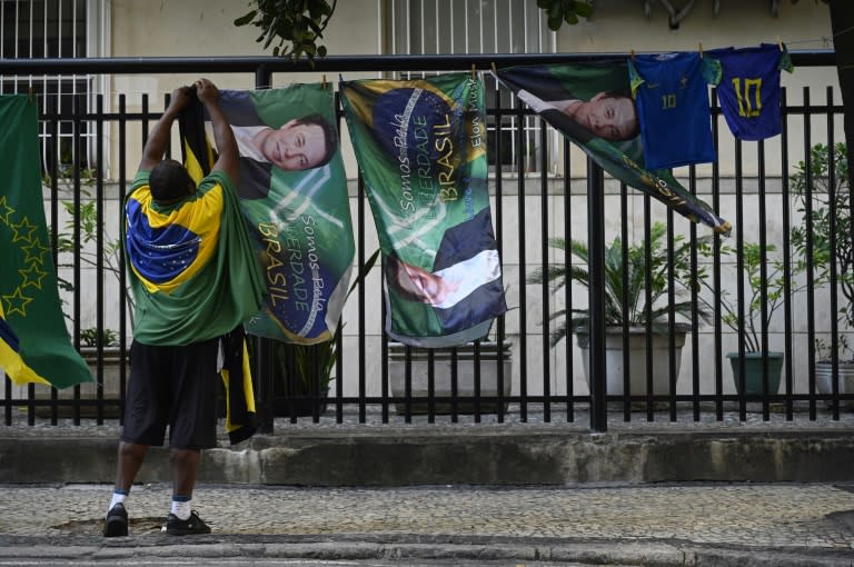 A man hangs flags with a portrait of tech tycoon Elon Musk during a demonstration called by former Brazilian President Jair Bolsonaro at Copacabana Beach in Rio de Janeiro, Brazil, on April 21, 2024 (MAURO PIMENTEL)