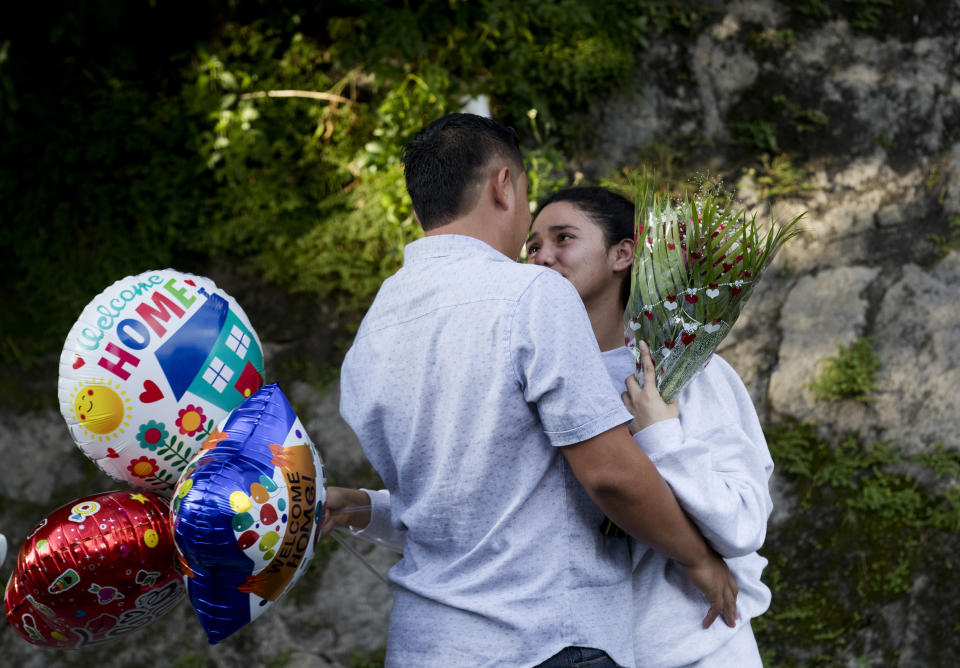 In this Oct. 9, 2019 photo, Ivania Morales, 19, is hugged by her boyfriend outside the Migrant Assistance Office in San Salvador, El Salvador. Buses with deported Salvadorans, such as Morales, arrive every day from the U.S. and Mexico. (AP Photo/Eduardo Verdugo)