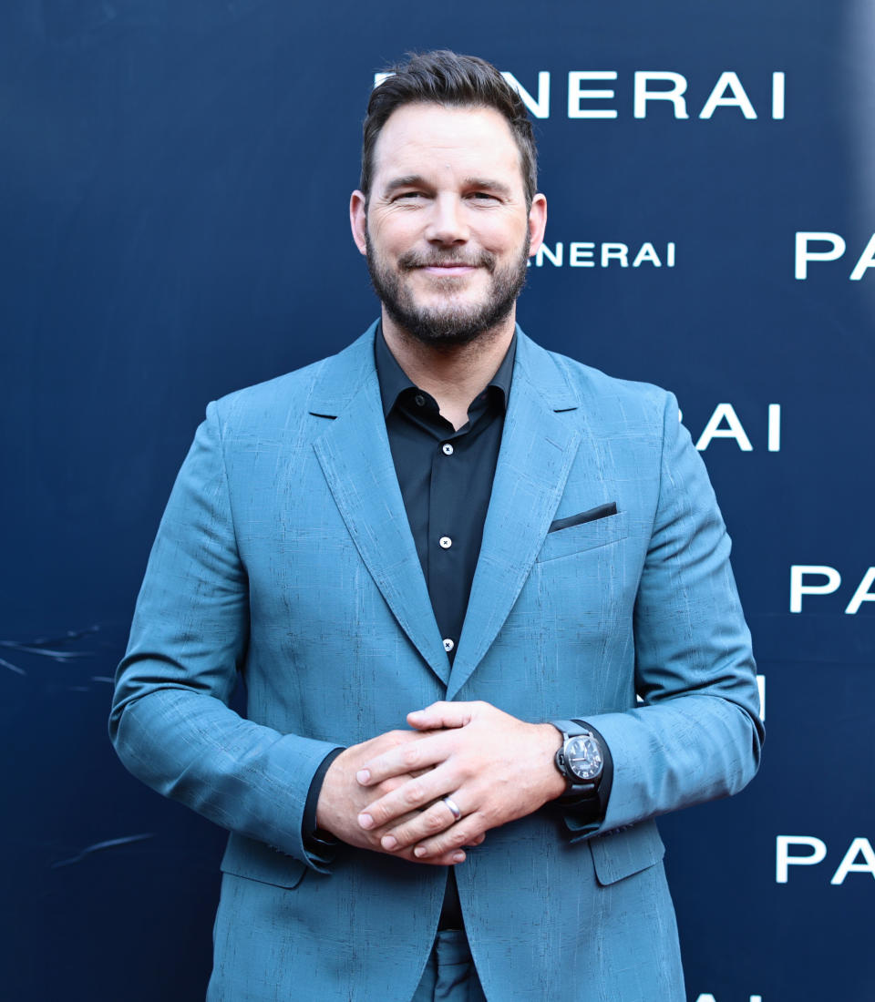 Chris Pratt in a tailored suit posing for the camera at a media event