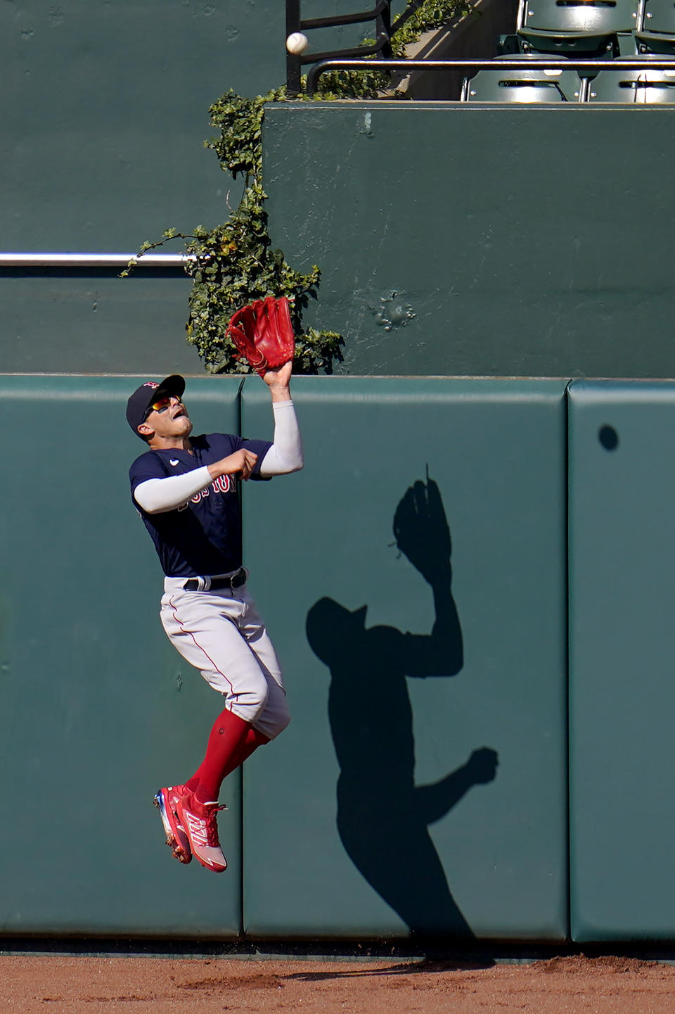 Boston Red Sox center fielder Enrique Hernandez goes up to make a catch near the wall on a ball hit by Baltimore Orioles' Rio Ruiz during the eighth inning of a baseball game, Sunday, April 11, 2021, in Baltimore. (AP Photo/Julio Cortez)