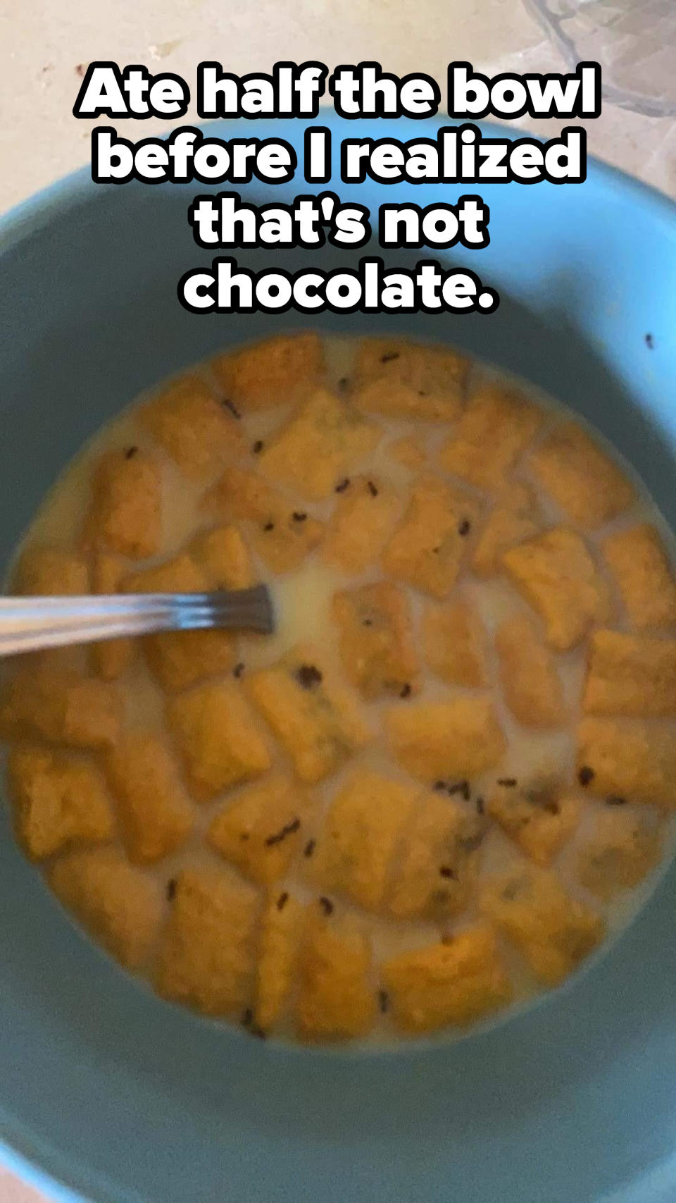 A bowl of cereal with small dark specks in it with the caption, "Ate half the bowl before I realized that's not chocolate"