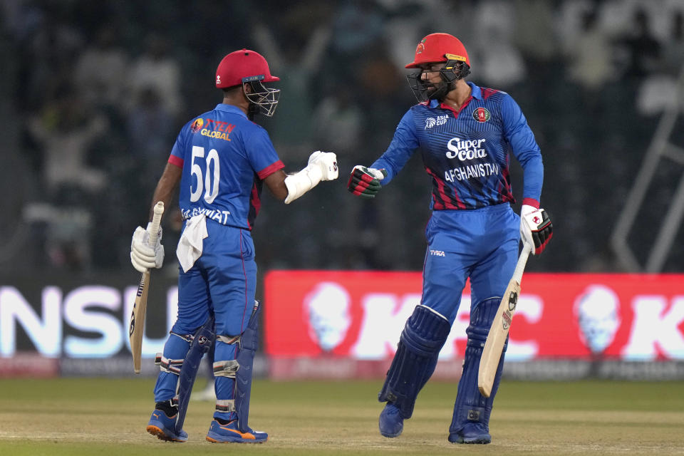 Afghanistan's Mohammad Nabi, right, celebrates with Hashmatullah Shahidi after hitting a boundary during the Asia Cup cricket match between Afghanistan and Sri Lanka in Lahore, Pakistan, Tuesday, Sept. 5, 2023. (AP Photo/K.M. Chaudary)