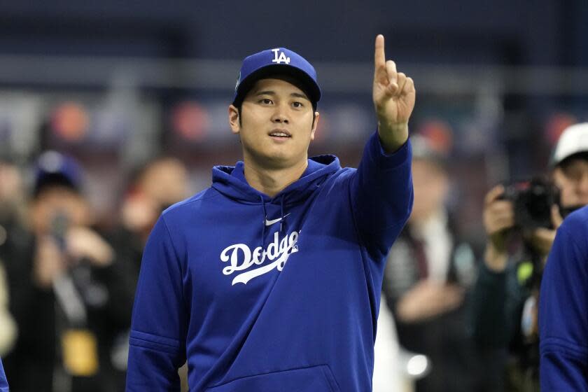 Los Angeles Dodgers designated hitter Shohei Ohtani gestures as he warms up.