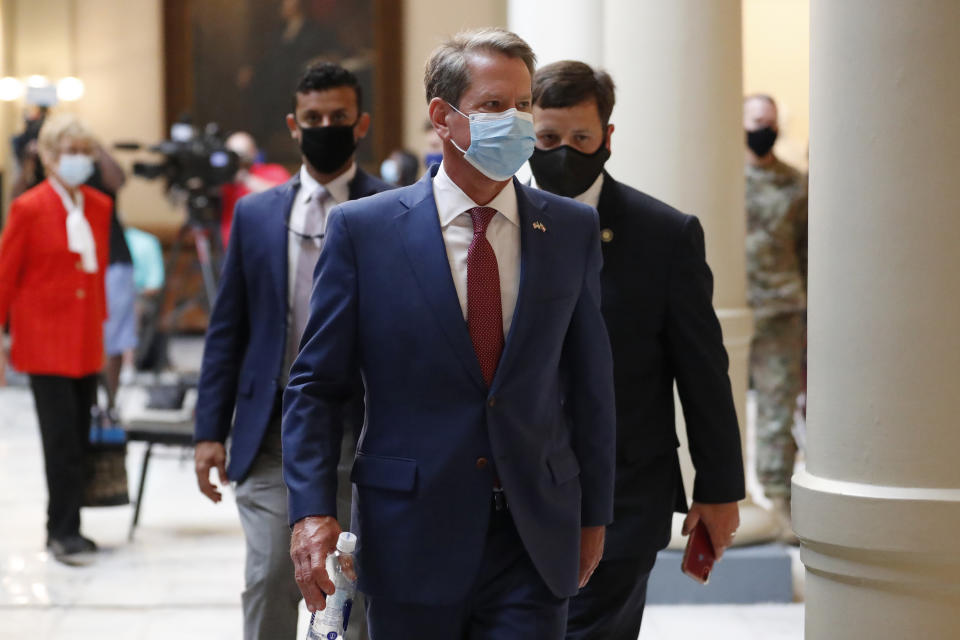 Georgia Gov. Brian Kemp returns to his office after giving a coronavirus briefing at the Capitol Friday, July 17, 2020, in Atlanta. Kemp is suing Atlanta Mayor Keisha Lance Bottoms over its face mask mandate. (AP Photo/John Bazemore)