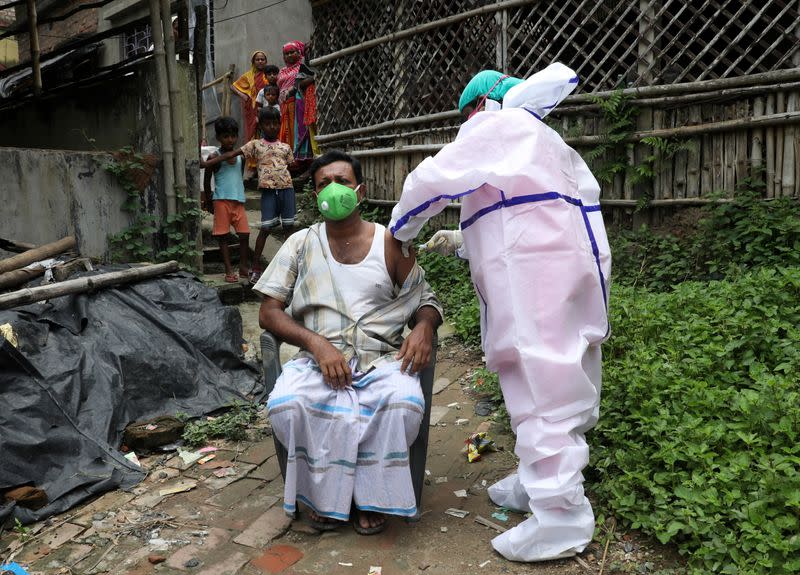 A villager receives a dose of COVISHIELD vaccine during a door-to-door vaccination and testing drive at Uttar Batora Island