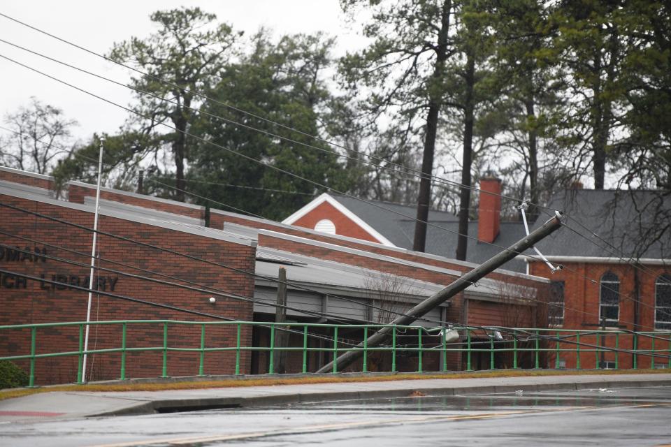 FILE - A power line leans against the railing near the Friedman Branch Library off Jackson Road on Tuesday, Jan. 9, 2024. A large storm front moved through the area in the afternoon, bringing a severe thunderstorm warning and a tornado watch.