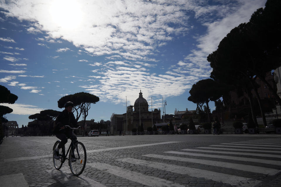 A lone cyclist rides along Via Dei Fori Imperiali (Road of the Imperial Forums) in Rome, Thursday, March 5, 2020. Italy closed all schools and universities and barred fans from all sporting events for the next few weeks, as governments trying to curb the spread of the coronavirus around the world resorted to increasingly sweeping measures that transformed the way people work, shop, pray and amuse themselves. (AP Photo/Andrew Medichini)