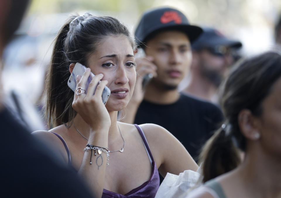 <p>Unas personas, conmocionadas, hablan por teléfono en una calle de Barcelona. (AP Foto/Manu Fernandez) </p>