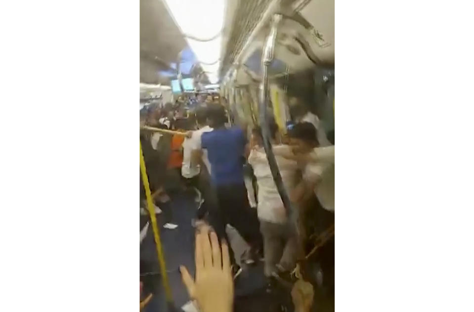 This Sunday, July 21, 2019, image made from a video, shows fighting inside a train car in Hong Kong. Protesters trying to return home were attacked inside a train station by assailants who appeared to target the pro-democracy demonstrators. (Lam Cheuk-ting via AP)