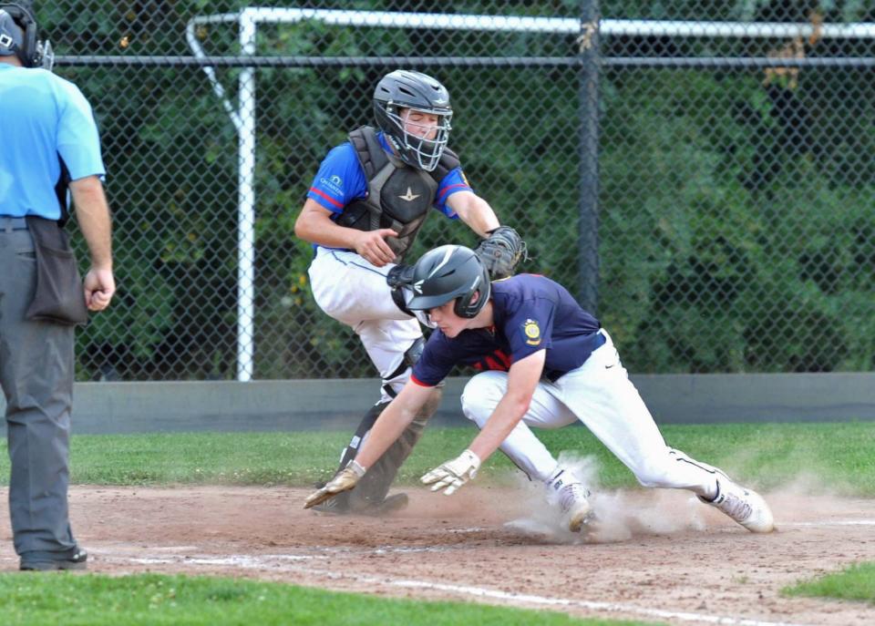 Hanover's Jake Pelish dives safely into home under the tag of Rockland catcher Spencer Merrick of Abington to score on Tanner Paul's pinch-hit, two-run single in the sixth inning of the District 10 American Legion Baseball Playoffs at Hanover High School, Wednesday, July 20, 2022.