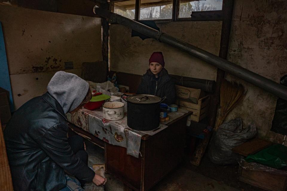 Zwei Schwestern sitzen in einer Hütte, die Vladimir und Igor gebaut haben, die in Kosharivka zurückgeblieben sind, um sich um die Alten und Kranken zu kümmern (Bel Trew)