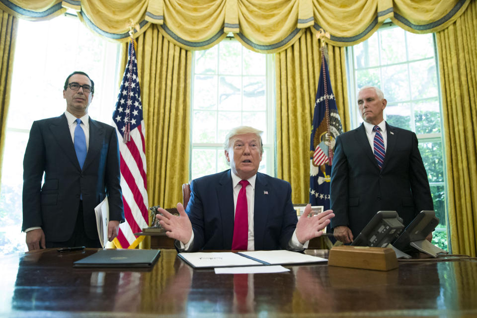 President Donald Trump listens to a reporter's question after signing an executive order to increase sanctions on Iran, in the Oval Office of the White House, Monday, June 24, 2019, in Washington. Trump is accompanied by Treasury Secretary Steve Mnuchin, left, and Vice President Mike Pence. (AP Photo/Alex Brandon)