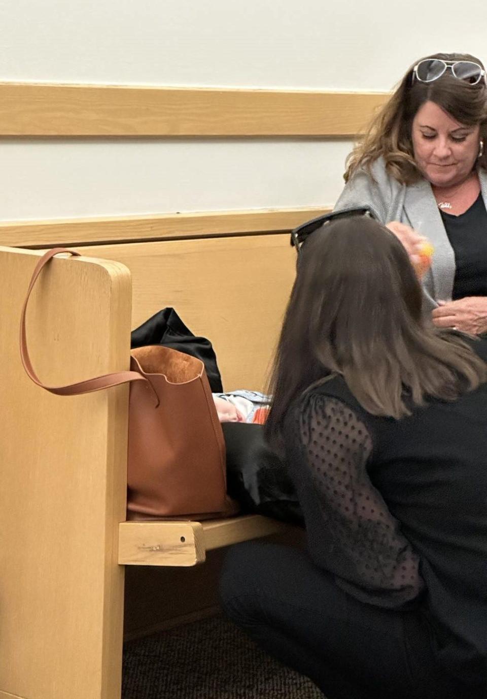 Amber McDaniel, left, kneels down to look at her son, nearly 18-month-old Phoenix, as his maternal grandmother, Dina Taylor, right, looks on Friday, Sept. 15, 2023, in the hallway outside of a courtroom at the Tim Curry Criminal Justice Center.
(Credit: Trish Choate/Times Record News)