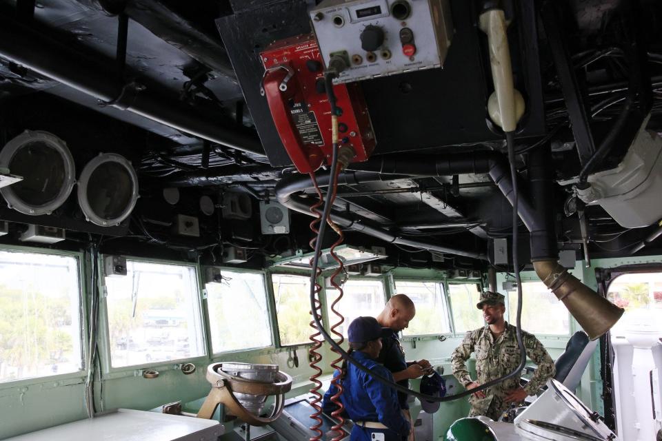 Petty Officer Juan Hall (right) talks with fellow Petty Officer Duane Lee and Chief Youdline Adam on the bridge of the USS Orleck as they and others from the U.S. Navy's Jacksonville recruitment office volunteered to clean up the ship for future museum duty.