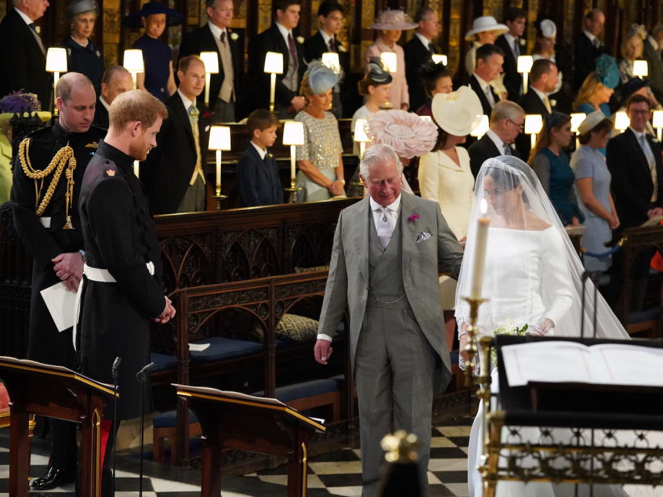 WINDSOR, UNITED KINGDOM - MAY 19:  Prince Harry looks at his bride, Meghan Markle, as she arrives accompanied by Prince Charles, Prince of Wales during their wedding in St George's Chapel at Windsor Castle on May 19, 2018 in Windsor, England. (Photo by Jonathan Brady - WPA Pool/Getty Images)