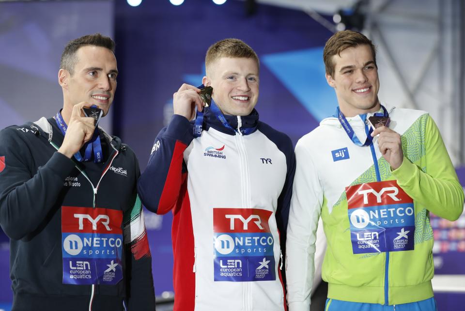 Silver medalist Fabio Scozzoli of Italy, left, gold medalist Adam Peaty of Great Britain, bronze medalist Peter John Stevens of Slovenia pose on the podium of the 50 meter breaststroke men final at the European Swimming Championships in Glasgow, Scotland, Wednesday, Aug. 8, 2018. (AP Photo/Darko Bandic)