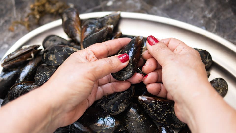 A good scrub is necessary to remove any remaining grit on the mussels. Scrub them gently with a vegetable brush or an old toothbrush under cool running water. - David Petrus Ibars/iStockphoto/Getty Images