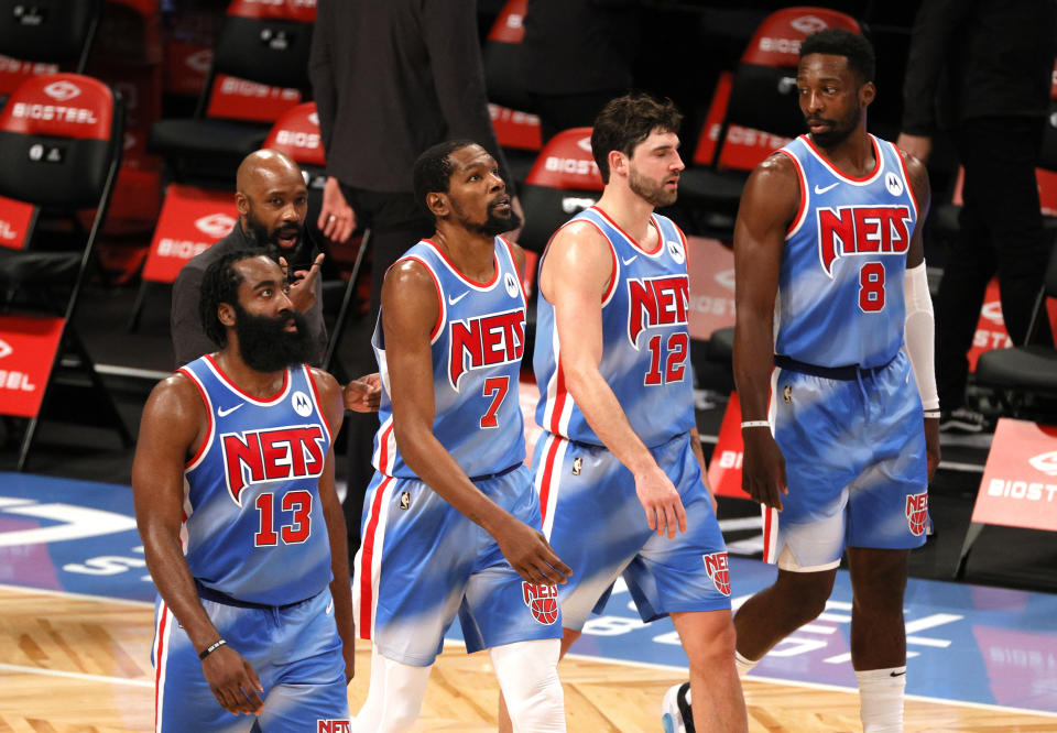 Los jugadores de baloncesto Harden, Durant, Harris y Green caminando por la pista.