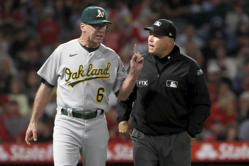 Oakland Athletics manager Bob Melvin, left, questions umpire Mark Carlson on a video replay decision during the seventh inning of the team's baseball game against the Los Angeles Angels in Anaheim, Calif., Saturday, Sept. 18, 2021. (AP Photo/Alex Gallardo)