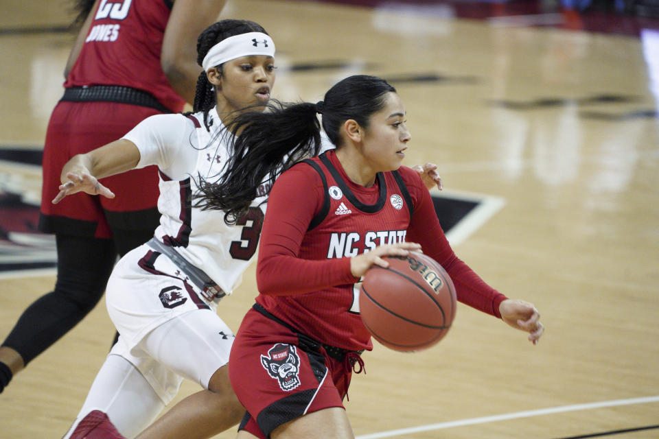 North Carolina State guard Raina Perez drives next to South Carolina guard Destanni Henderson (3) during the first half of an NCAA college basketball game Thursday, Dec. 3, 2020, in Columbia, S.C. N.C. State won 54-46. (AP Photo/Sean Rayford)