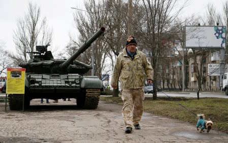 FILE PHOTO: A man walks past a tank, part of a military exposition in Donetsk