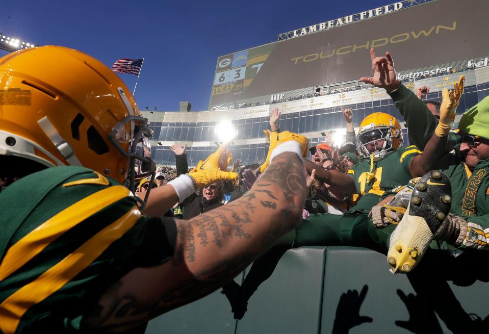 Wide receivers Christian Watson and Jayden Reed (in the stands) celebrate after a touchdown against the Los Angeles Chargers on Nov. 19 at Lambeau Field. The Packers selected Watson (2022) and Reed (2023) with second-round picks in the NFL draft.