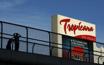 FILE - People stand on a pedestrian bridge by the Tropicana hotel and casino, Aug. 4, 2015, in Las Vegas. The Tropicana Las Vegas, a Sin City namesake for more than six decades, is slated to shut its doors in April 2024 to make room for a $1.5 billion Major League Baseball stadium, Bally's Corp. announced Monday, Jan. 29, 2024. (AP Photo/John Locher, File)