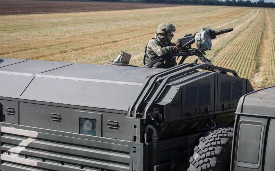 Russian serviceman on a military vehicle keeping watch in a field near Melitopol, Zaporizhia region - Shutterstock
