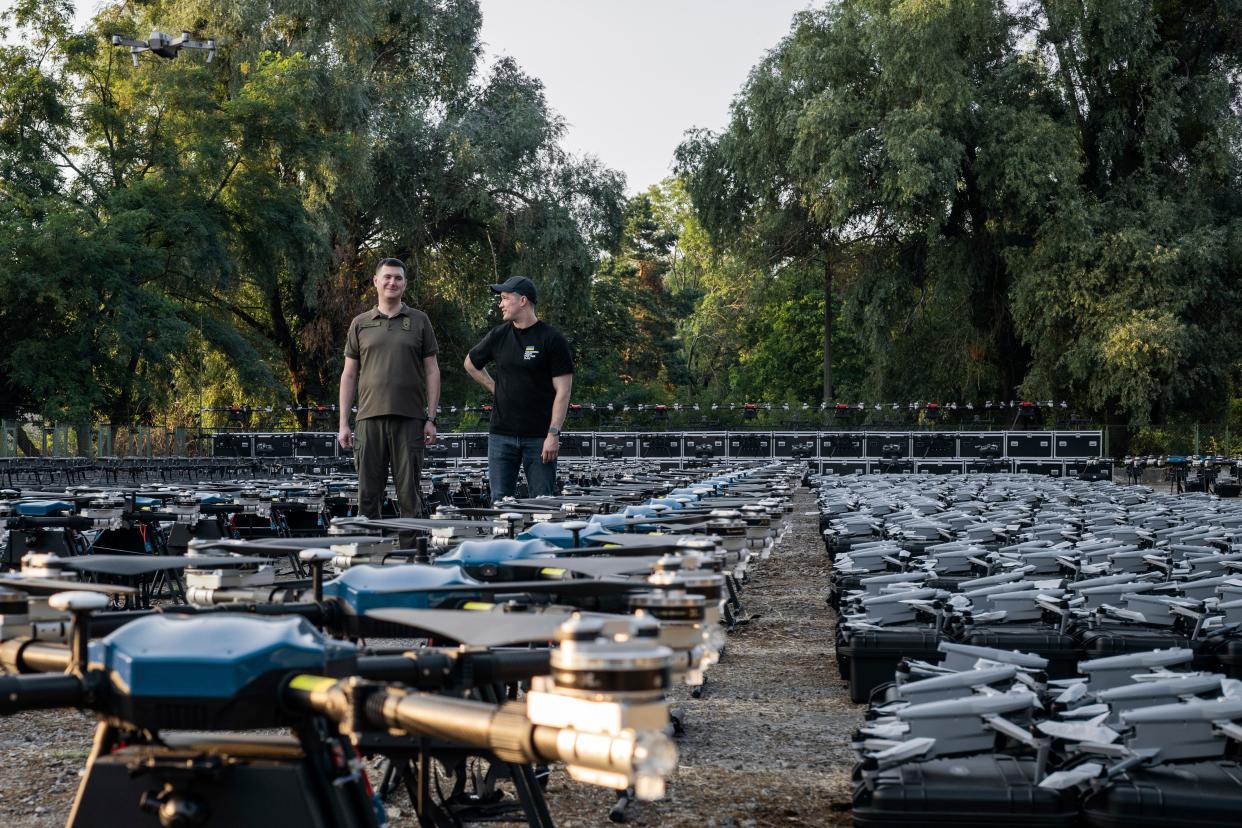Ukrainian minister of digital transformation Mykhailo Fedorov, right, and head of State Special Communications Service Yuriy Shchygol stand among 1,700 drones that are being sent to the frontline to be used against Russian forces in Ukraine (AP)