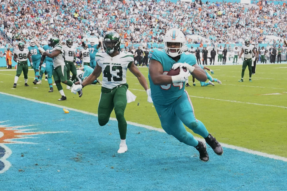 Miami Dolphins defensive end Christian Wilkins (94) scores a touchdown as New York Jets linebacker Del'Shawn Phillips (43) missed the tackle during the second half of an NFL football game, Sunday, Dec. 19, 2021, in Miami Gardens, Fla. (AP Photo/Wilfredo Lee)