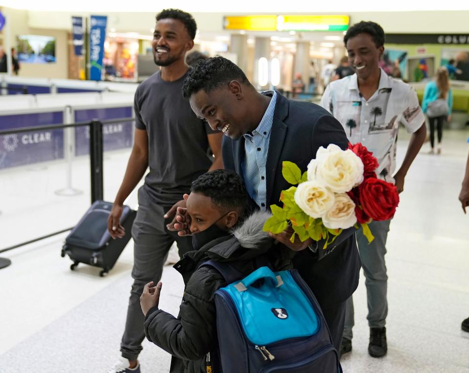 Afkab Hussein smiles Thursday while hugging his son Abdullahi, 6, at John Glenn Columbus International Airport, where he was reunited with his family after six years. Hussein moved to the United States from Kenya as a refugee without his pregnant wife, whose efforts to join him were delayed by bans on refugee admissions and travel from seven Muslim-majority countries during the Trump administration.
