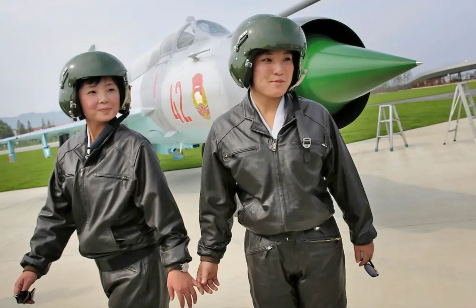 Two female pilots make an appearance in front of a MiG-21 fighter during North Korea’s first airshow in 2016. <em>AP</em>