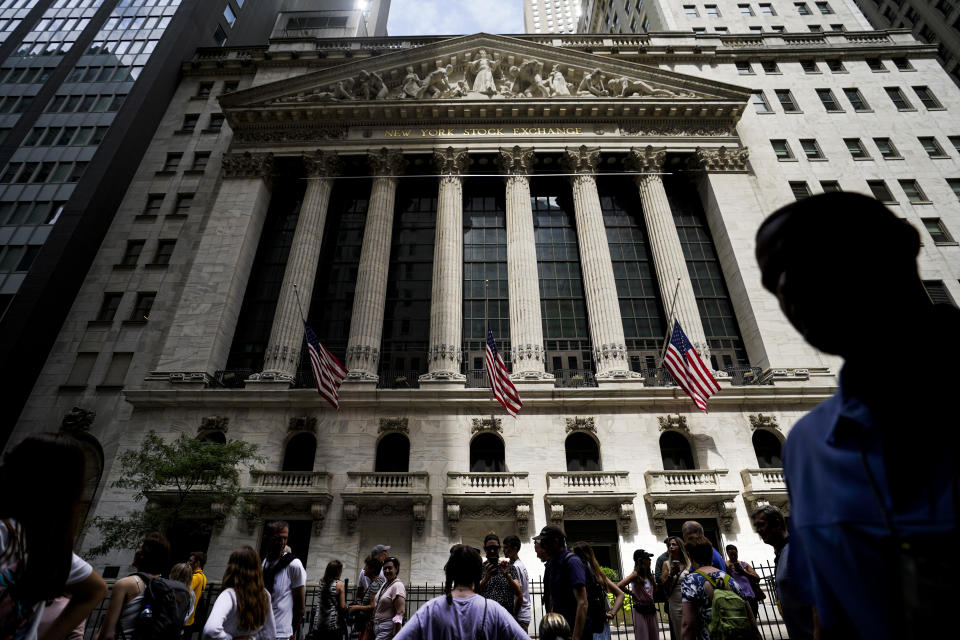 FILE - Pedestrians walk past the New York Stock Exchange on Friday, July 8, 2022, in New York. Stocks wavered between gains and losses in morning trading on Wall Street Monday, Aug. 1, 2022 as investors face another busy week of corporate earnings reports and economic updates. (AP Photo/John Minchillo, File)